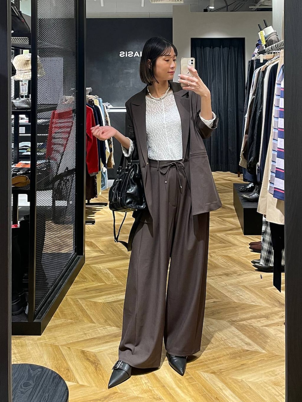 ブラック系のボストンバッグ、ブラウン系のテーラードジャケット、ブラック系のパンプスを着用したレディースの冬コーディネートの2枚目の写真