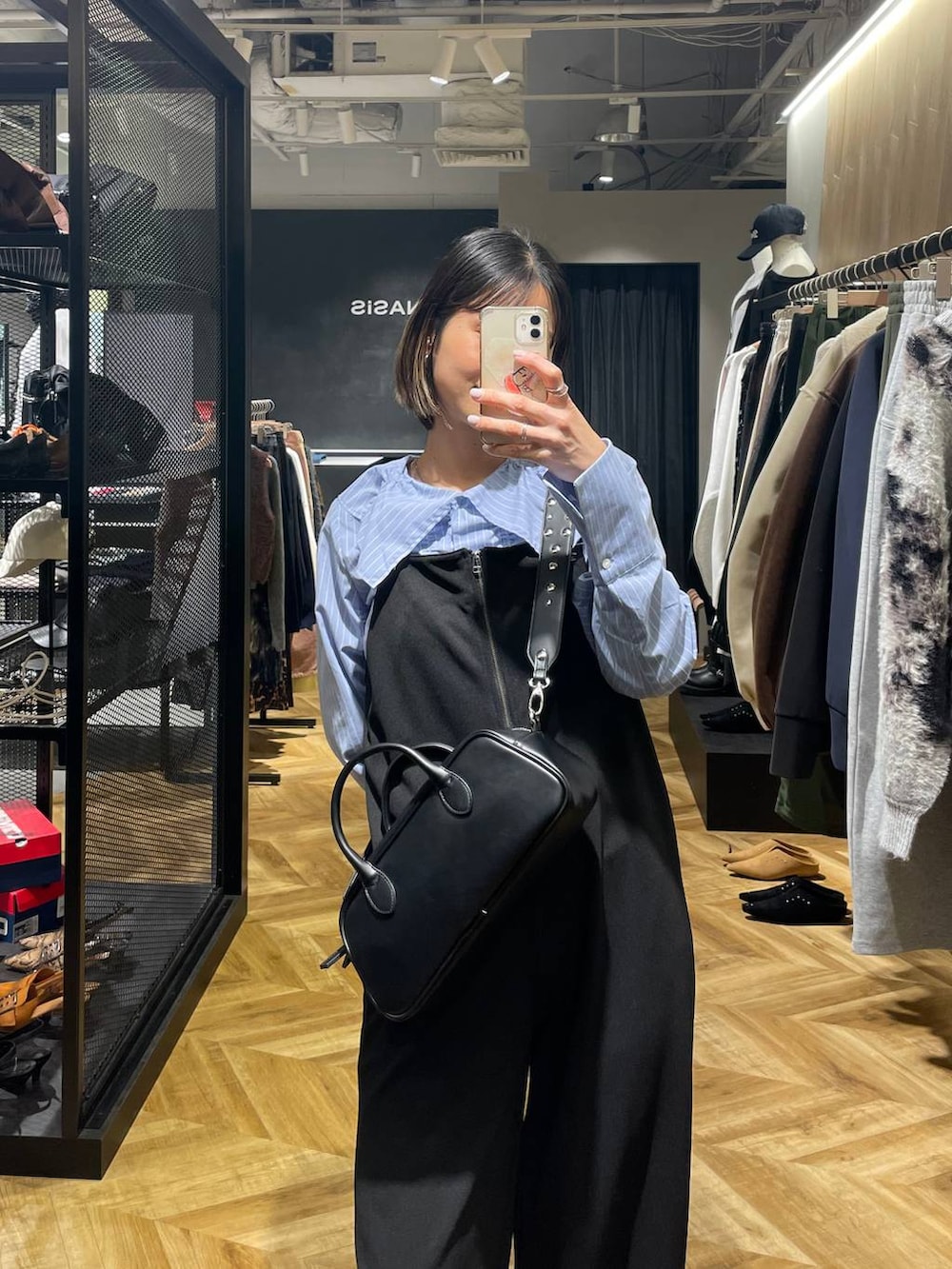 ブラック系のサロペット/オーバーオール、ブラック系のボストンバッグ、ブラック系のローファーを着用したレディースの冬コーディネートの3枚目の写真