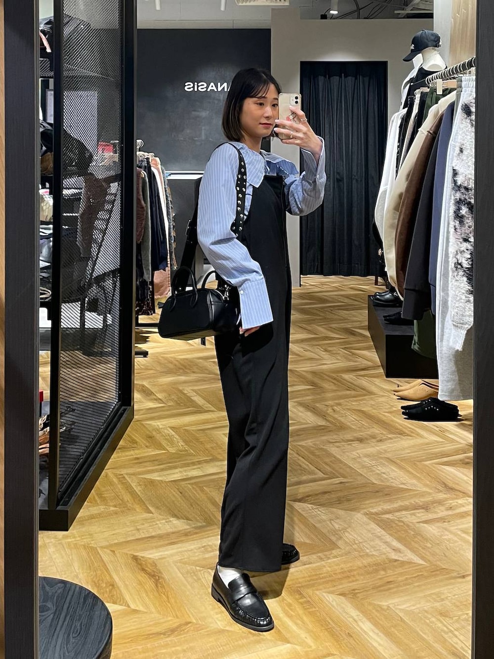 ブラック系のサロペット/オーバーオール、ブラック系のボストンバッグ、ブラック系のローファーを着用したレディースの冬コーディネートの4枚目の写真