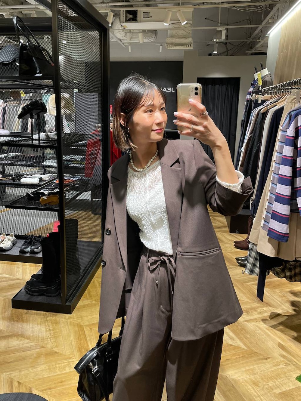 ブラック系のボストンバッグ、ブラウン系のテーラードジャケット、ブラック系のパンプスを着用したレディースの冬コーディネートの3枚目の写真