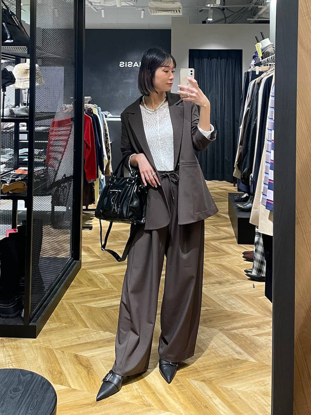 ブラック系のボストンバッグ、ブラウン系のテーラードジャケット、ブラック系のパンプスを着用したレディースの冬コーディネートの5枚目の写真