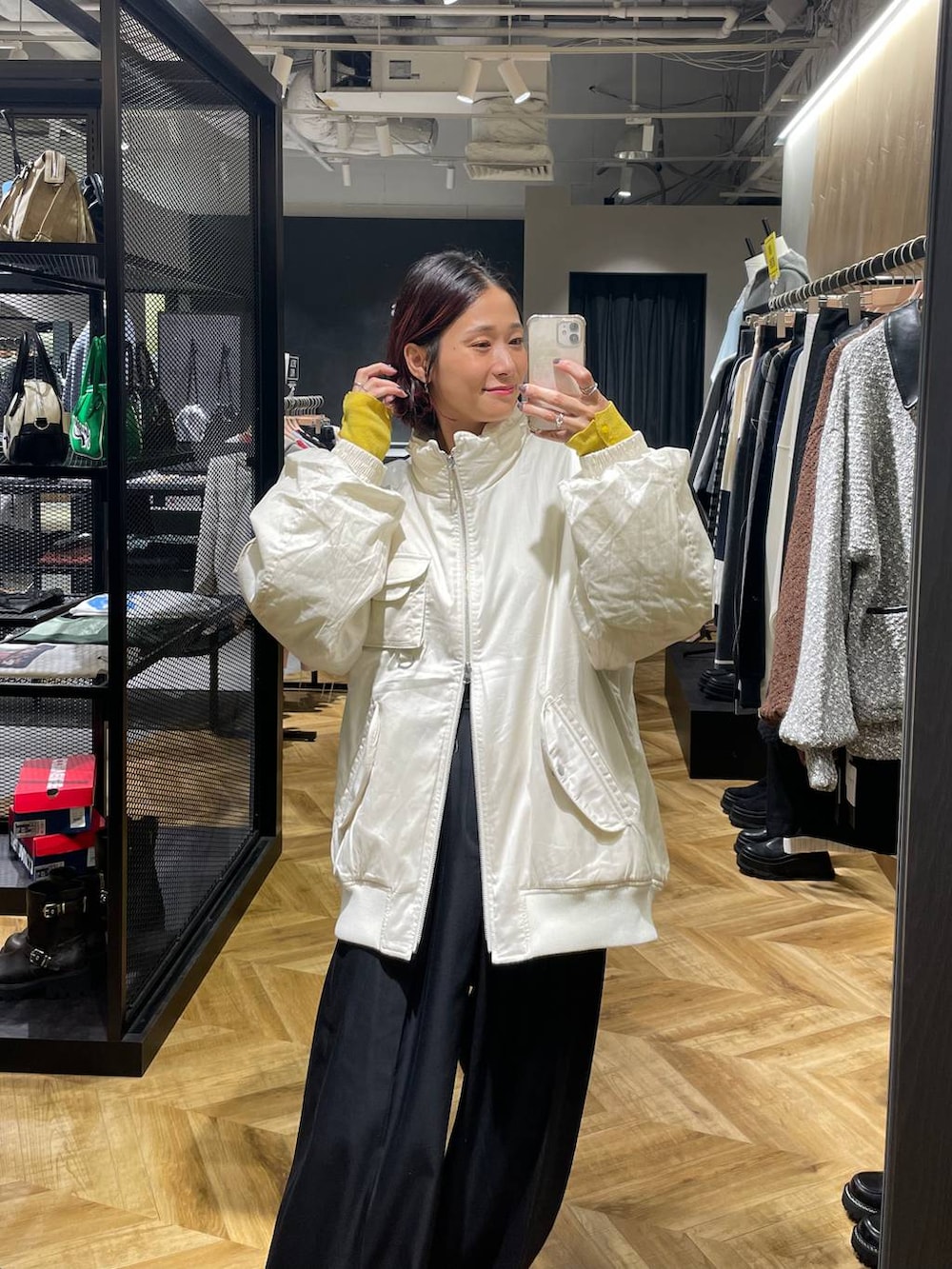 ホワイト系のブルゾン、ブラック系のローファー、ブラック系のスラックスを着用したレディースの秋コーディネートの3枚目の写真