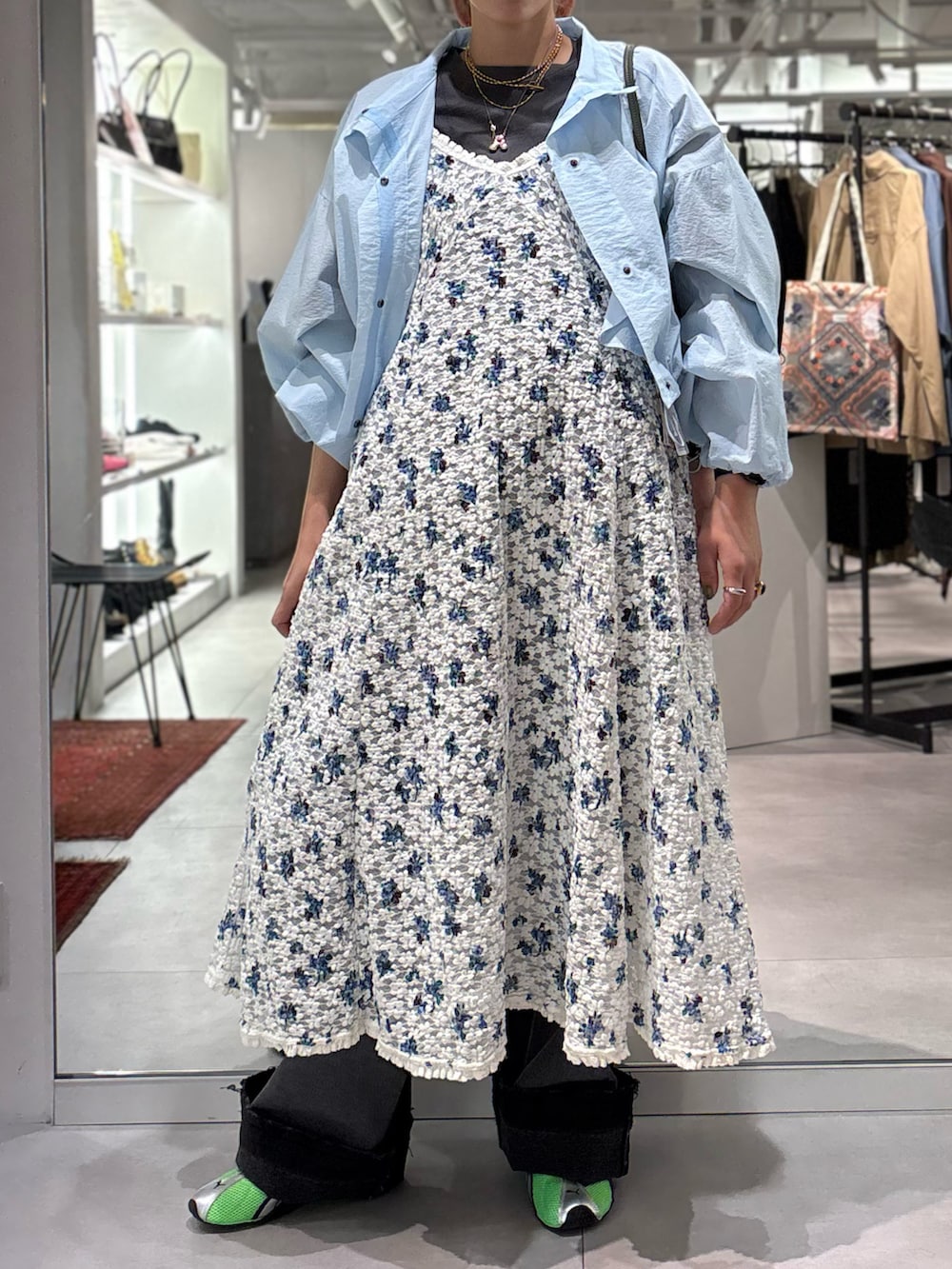 ホワイト系のワンピース、ブルー系のブルゾン、ブラック系のデニムパンツを着用したレディースの春コーディネートの4枚目の写真