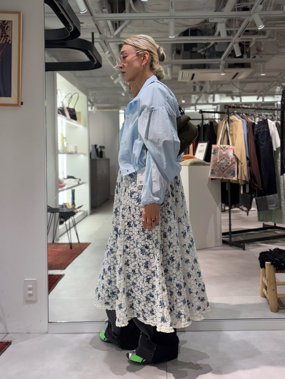 ホワイト系のワンピース、ブルー系のブルゾン、ブラック系のデニムパンツを着用したレディースの春コーディネートの2枚目の写真