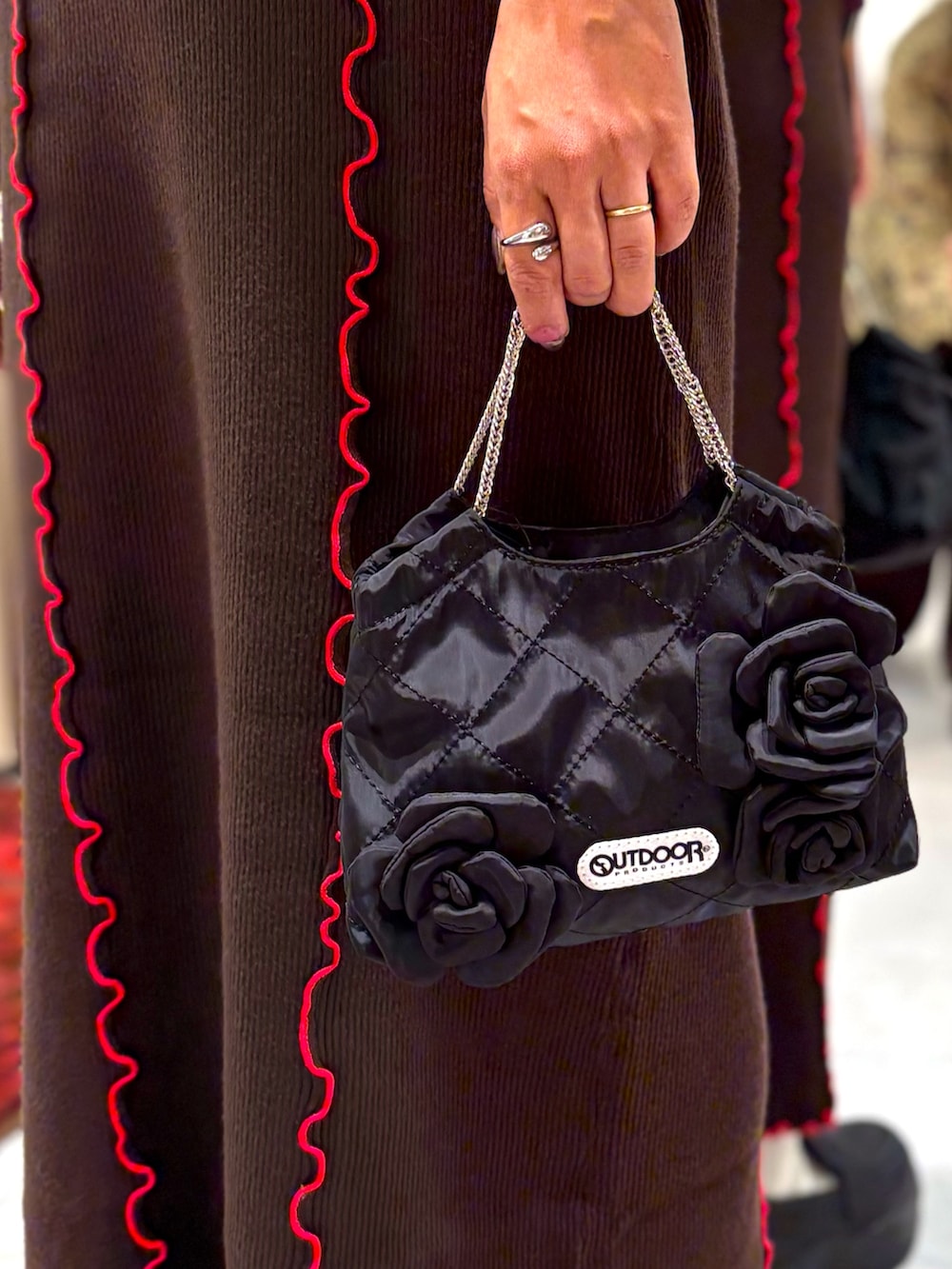 レッド系のスウェット、ブラウン系のスカート、ブラック系のトートバッグを着用したレディースの秋コーディネートの6枚目の写真