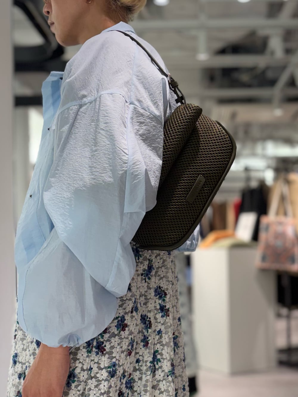 ホワイト系のワンピース、ブルー系のブルゾン、ブラック系のデニムパンツを着用したレディースの春コーディネートの6枚目の写真