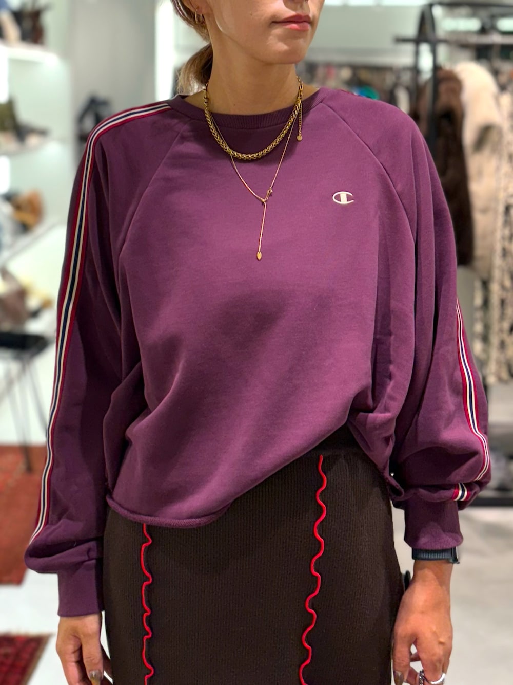 レッド系のスウェット、ブラウン系のスカート、ブラック系のトートバッグを着用したレディースの秋コーディネートの4枚目の写真