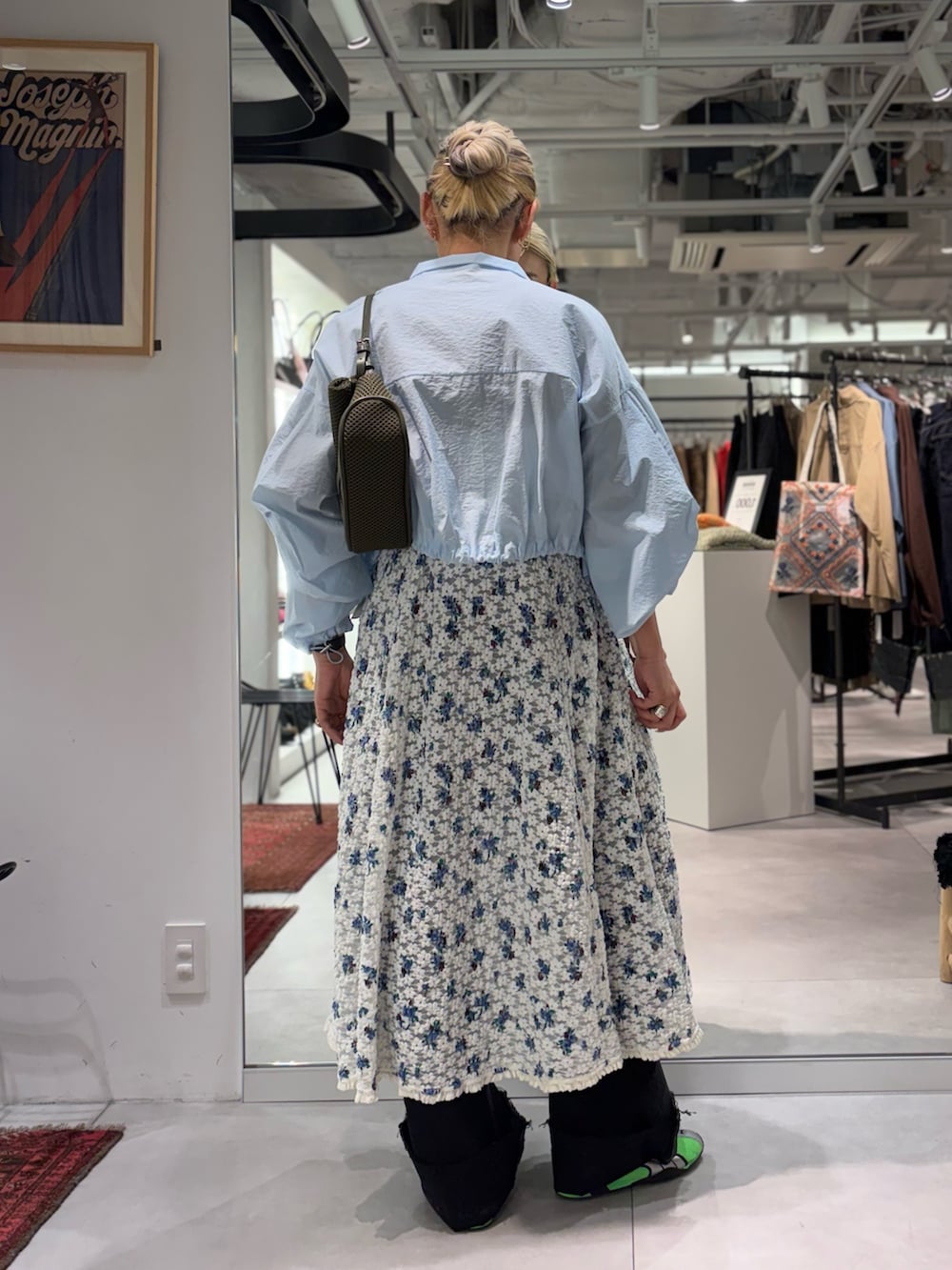 ホワイト系のワンピース、ブルー系のブルゾン、ブラック系のデニムパンツを着用したレディースの春コーディネートの3枚目の写真