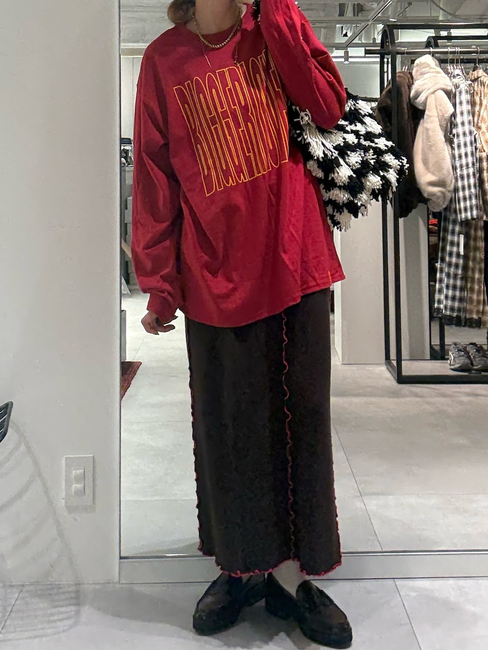 レッド系のTシャツ/カットソー、ブラウン系のスカート、ブラック系のローファーを着用したレディースの秋コーディネートの4枚目の写真