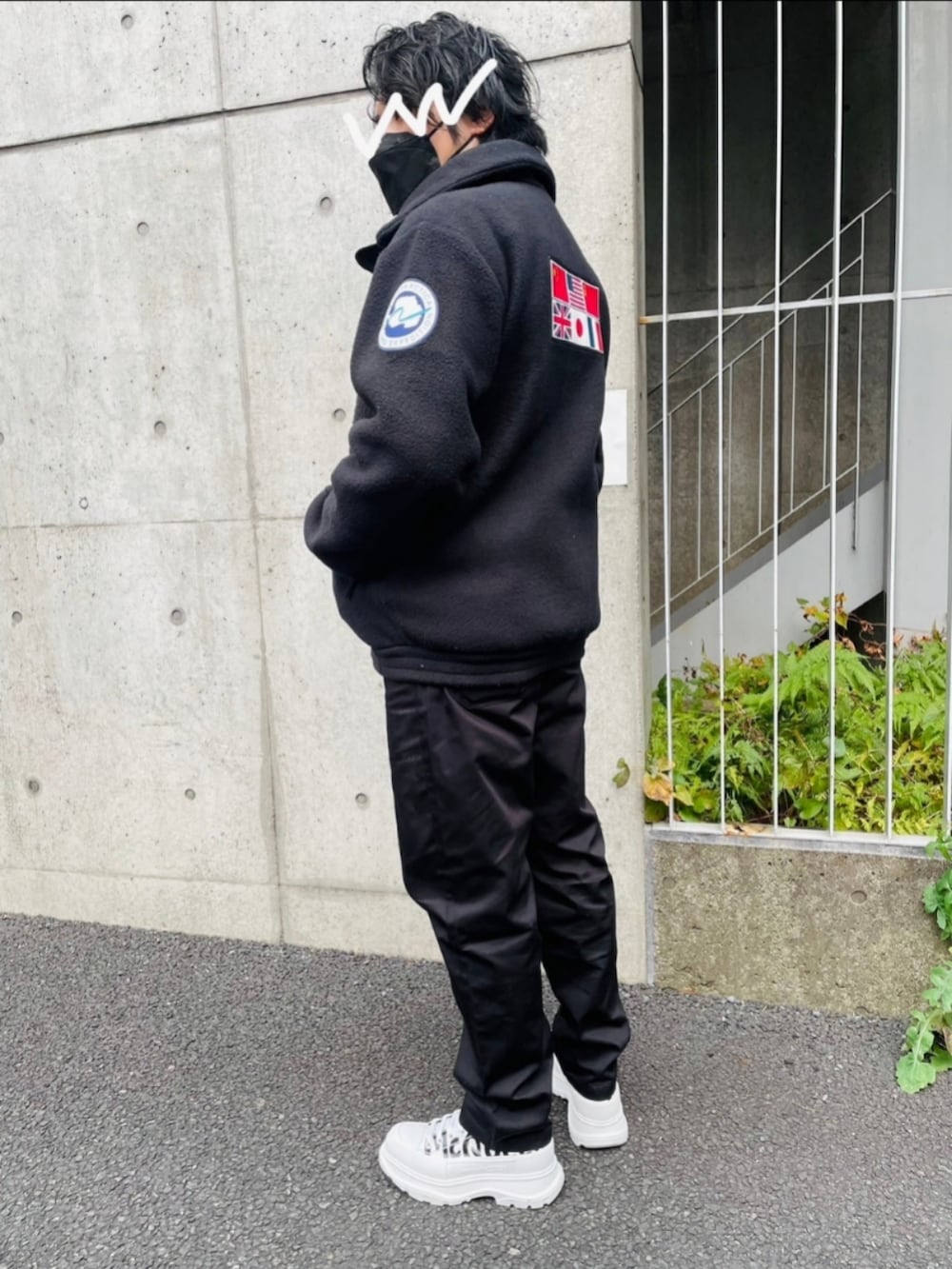 ブラック系のその他アウター、グレー系のチノパンツ、ホワイト系のスニーカーを着用したメンズの冬コーディネートの2枚目の写真