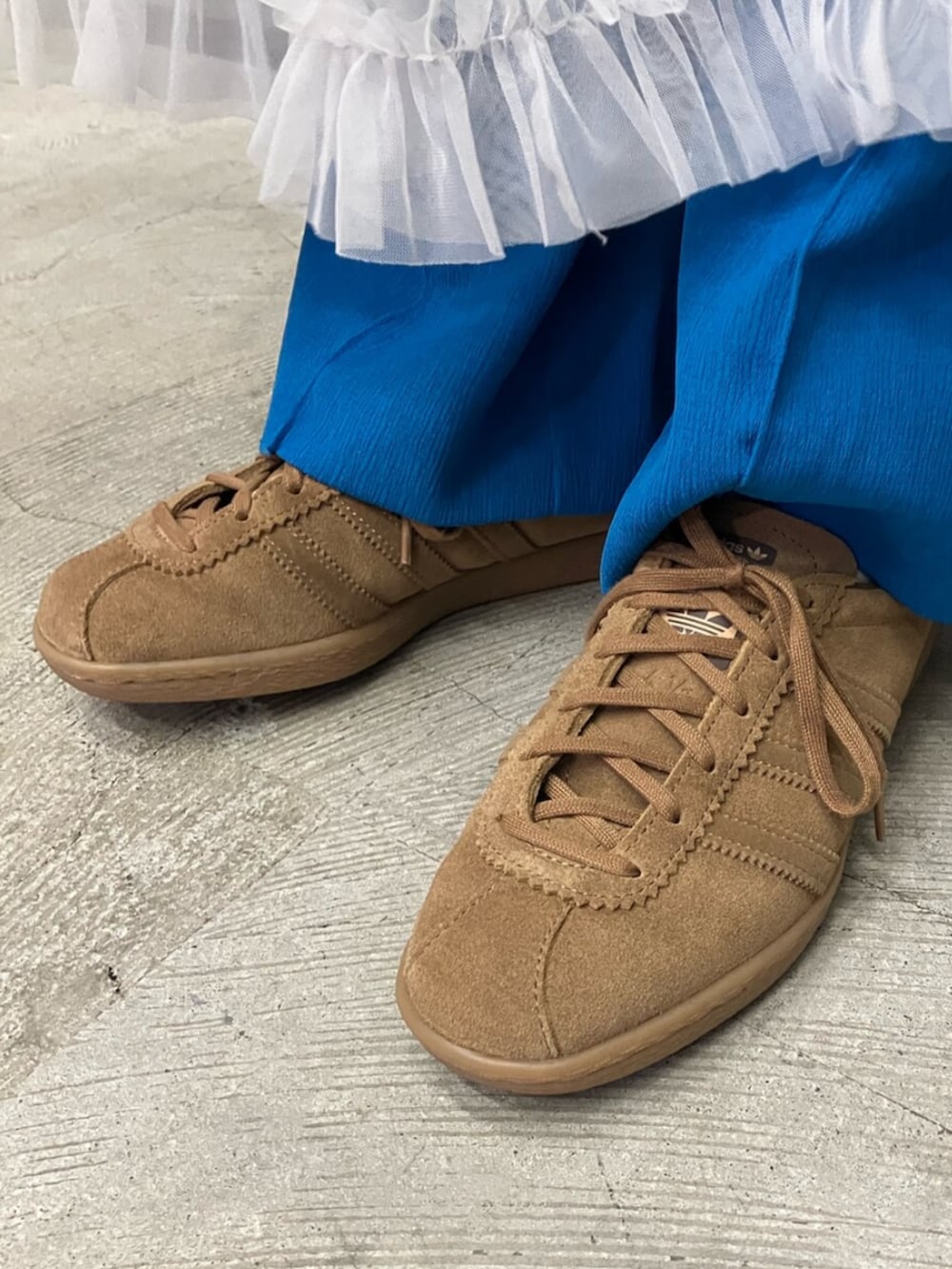 ブラウン系のスニーカー、ブラック系のデニムジャケットを着用したレディースの秋コーディネートの2枚目の写真