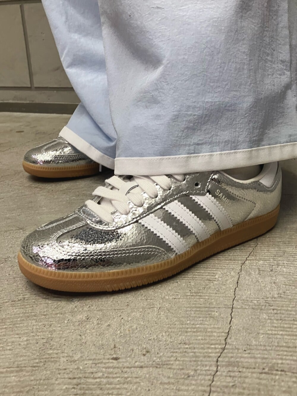 ブルー系のデニムジャケット、ブルー系のスウェットパンツ、シルバー系のスニーカーを着用したレディースの春コーディネートの2枚目の写真