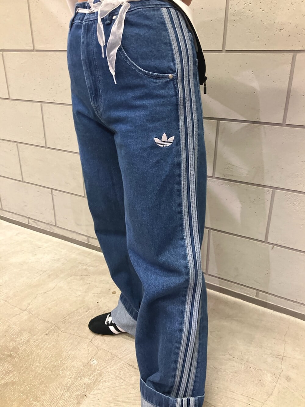 ブルー系のデニムパンツ、ブラック系のジャージ、ホワイト系のTシャツ/カットソーを着用したレディースの冬コーディネートの3枚目の写真