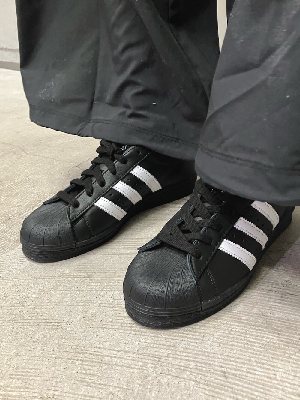 ブラック系のジャージ、ブラック系のスウェットパンツ、ブラック系のシューズを着用したレディースの冬コーディネートの4枚目の写真