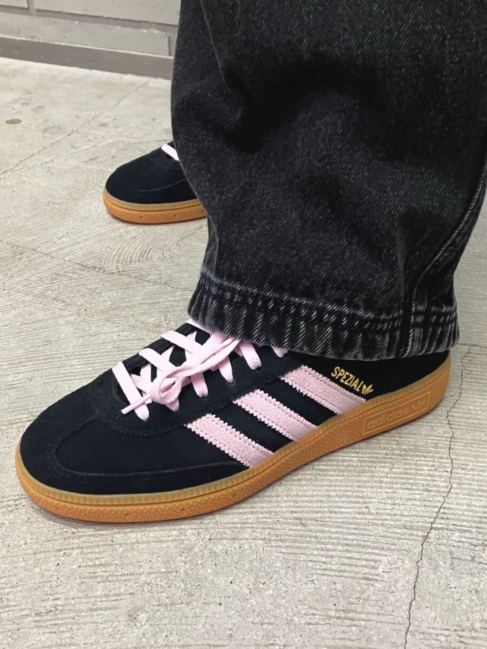 ブラック系のダウンジャケット/コート、ブラック系のデニムパンツ、ブラック系のスニーカーを着用したレディースの春コーディネートの2枚目の写真