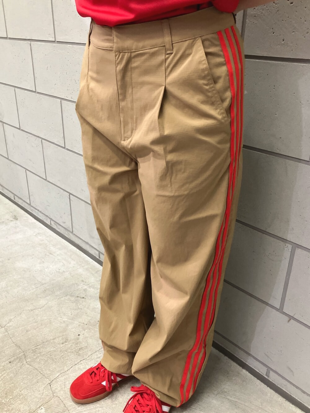 レッド系のスニーカー、ベージュ系のその他パンツ、レッド系のTシャツ/カットソーを着用したレディースの夏コーディネートの5枚目の写真