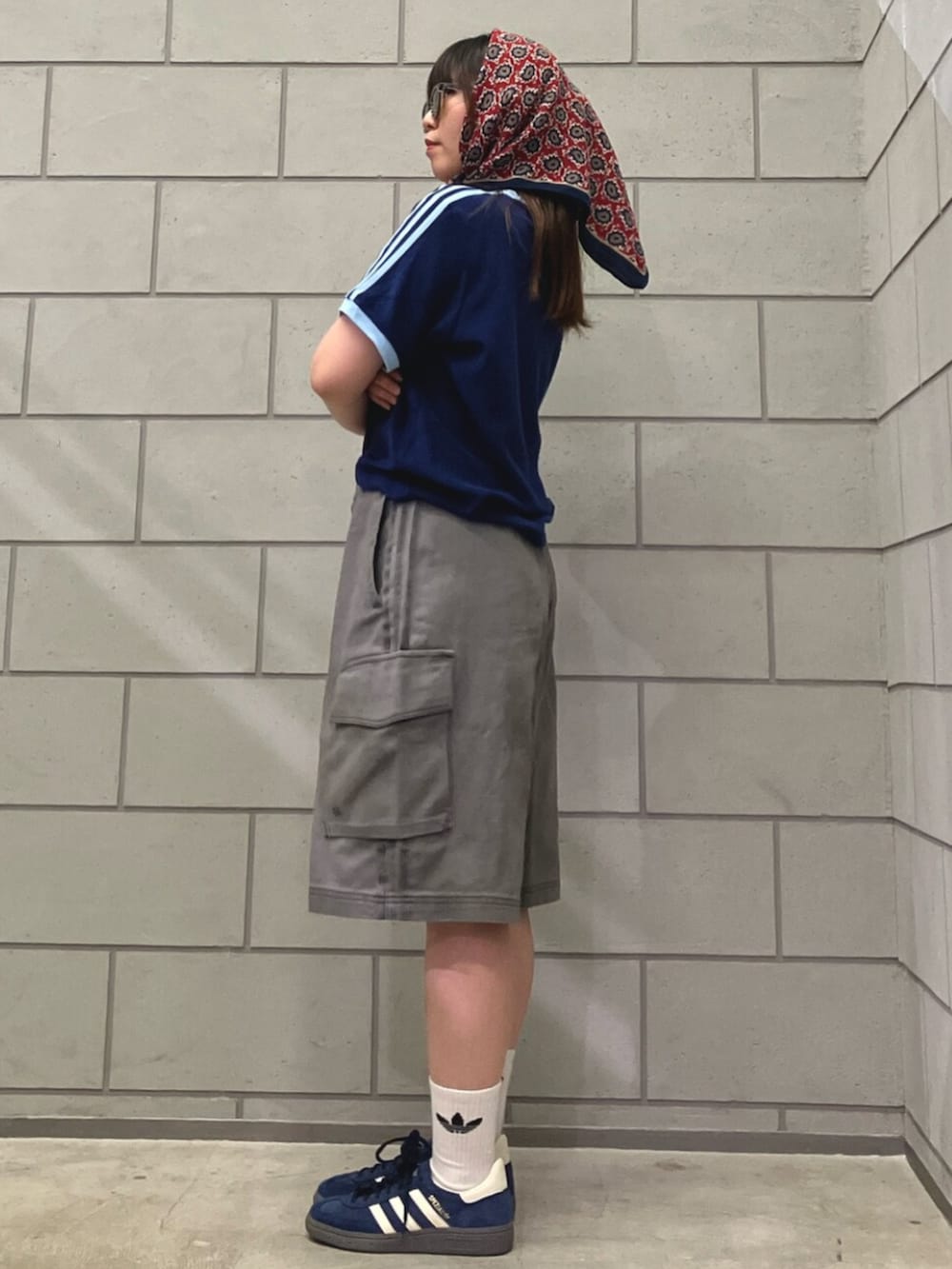 ブルー系のTシャツ/カットソー、ブラック系のカーゴパンツ、ブルー系のスニーカーを着用したレディースの春コーディネートの2枚目の写真