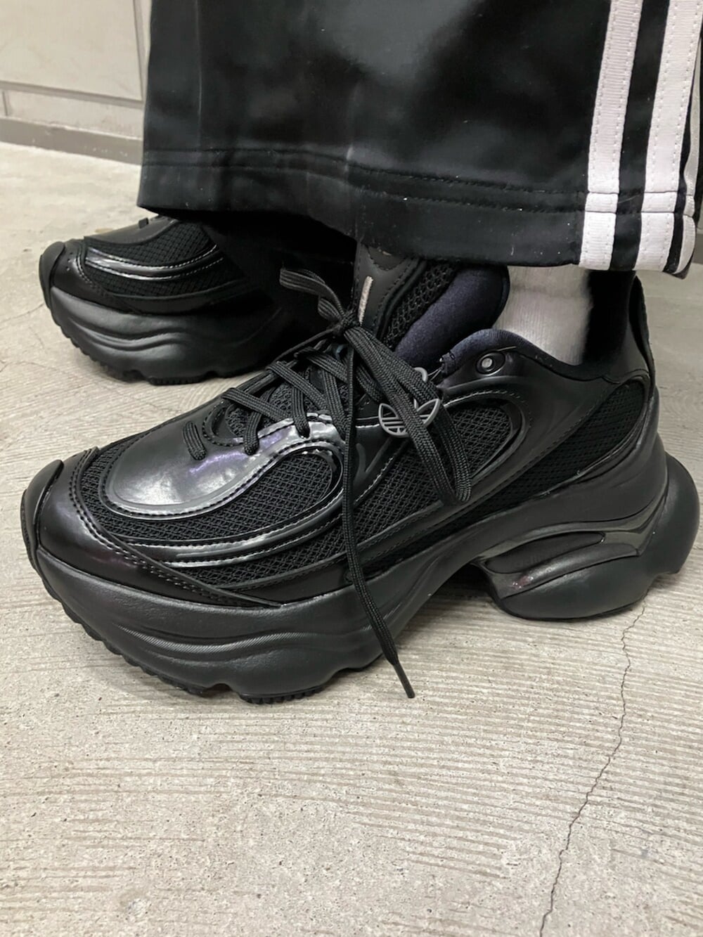 ブラック系のブルゾン、ブラック系のスウェットパンツ、ブラック系のスニーカーを着用したレディースの冬コーディネートの4枚目の写真