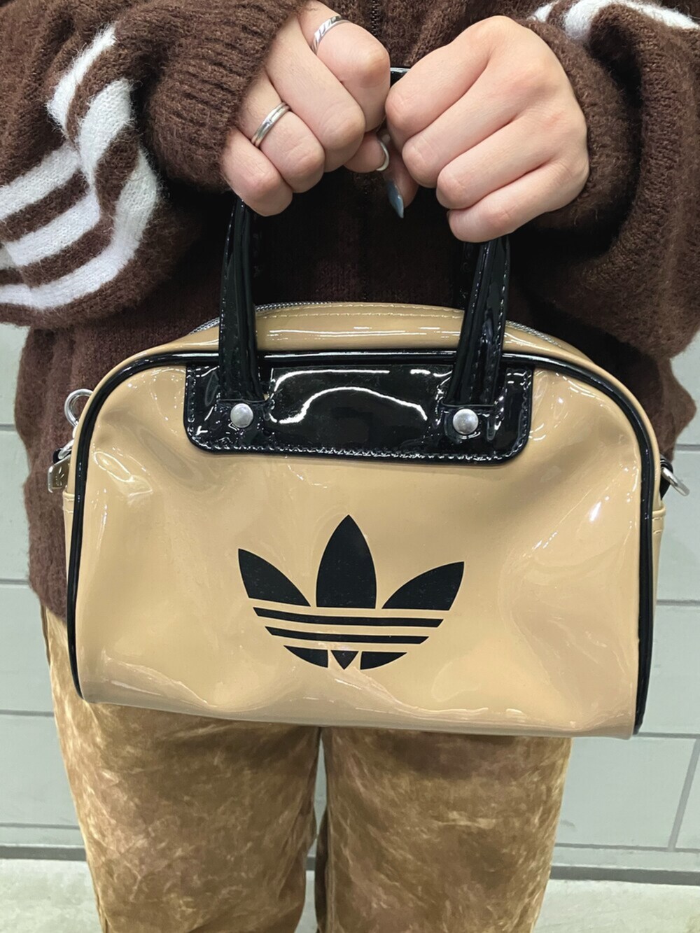 ベージュ系のショルダーバッグ、ブラウン系のその他パンツ、ベージュ系のスニーカーを着用したレディースの秋コーディネートの4枚目の写真
