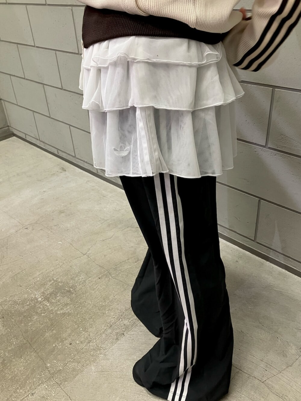 ホワイト系のジャージ、ブラック系のスウェットパンツ、ブラック系のシューズを着用したレディースの冬コーディネートの3枚目の写真