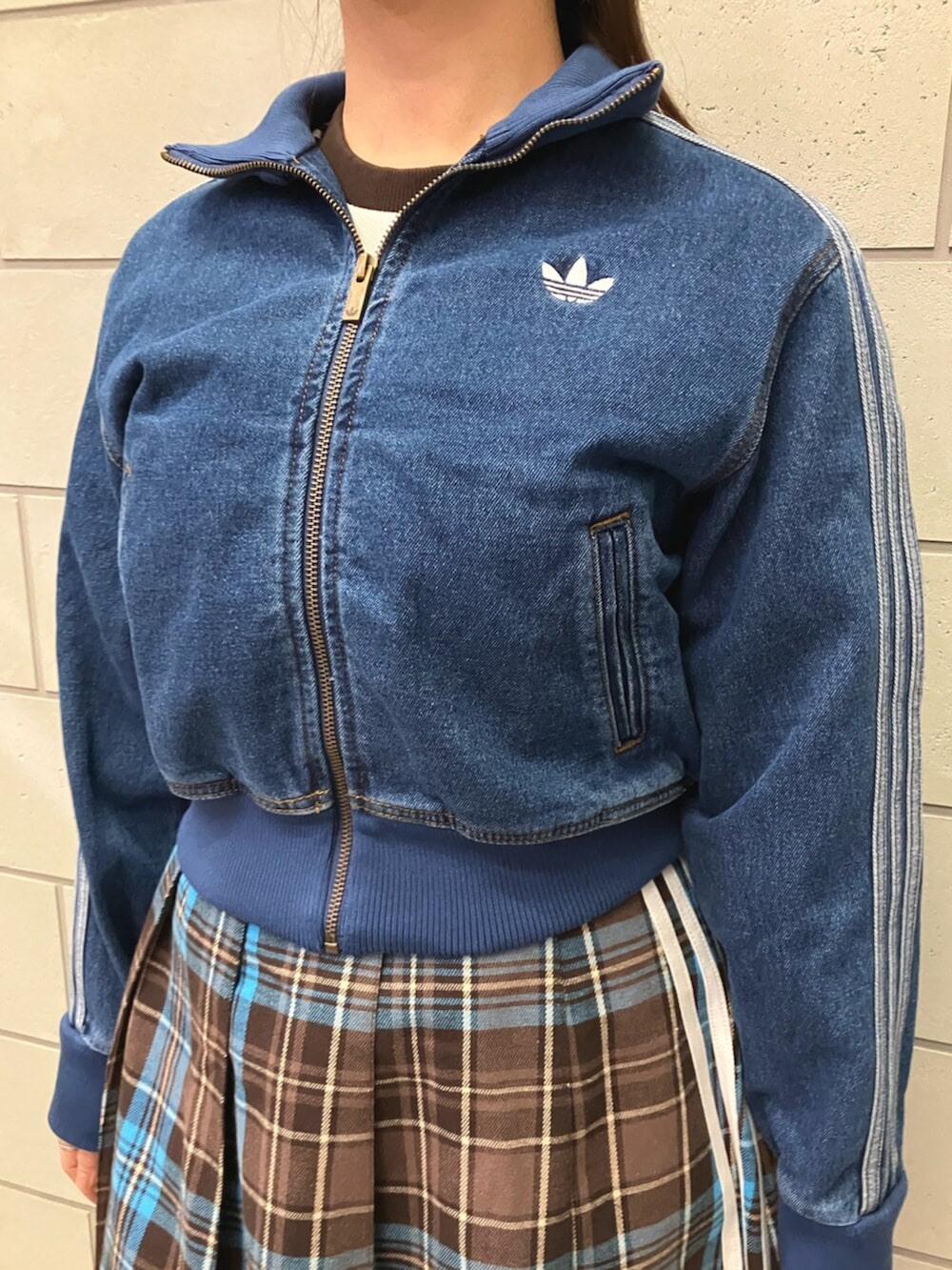 ブルー系のジャージ、ブラウン系のスカート、ホワイト系のスニーカーを着用したレディースの冬コーディネートの2枚目の写真