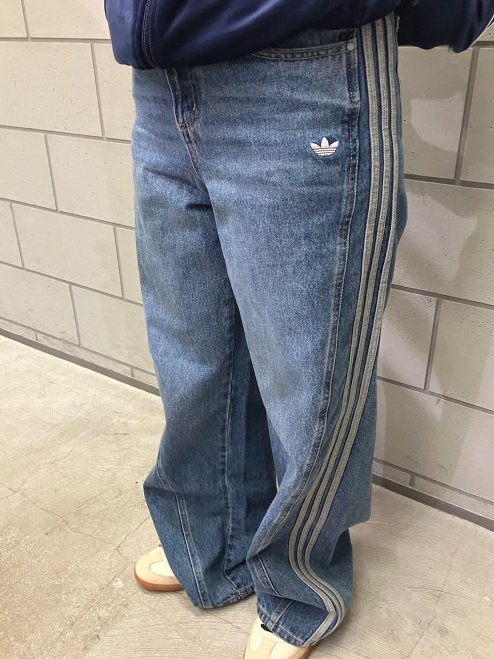 ブルー系のジャージ、ブルー系のデニムパンツ、ベージュ系のスニーカーを着用したレディースの冬コーディネートの3枚目の写真