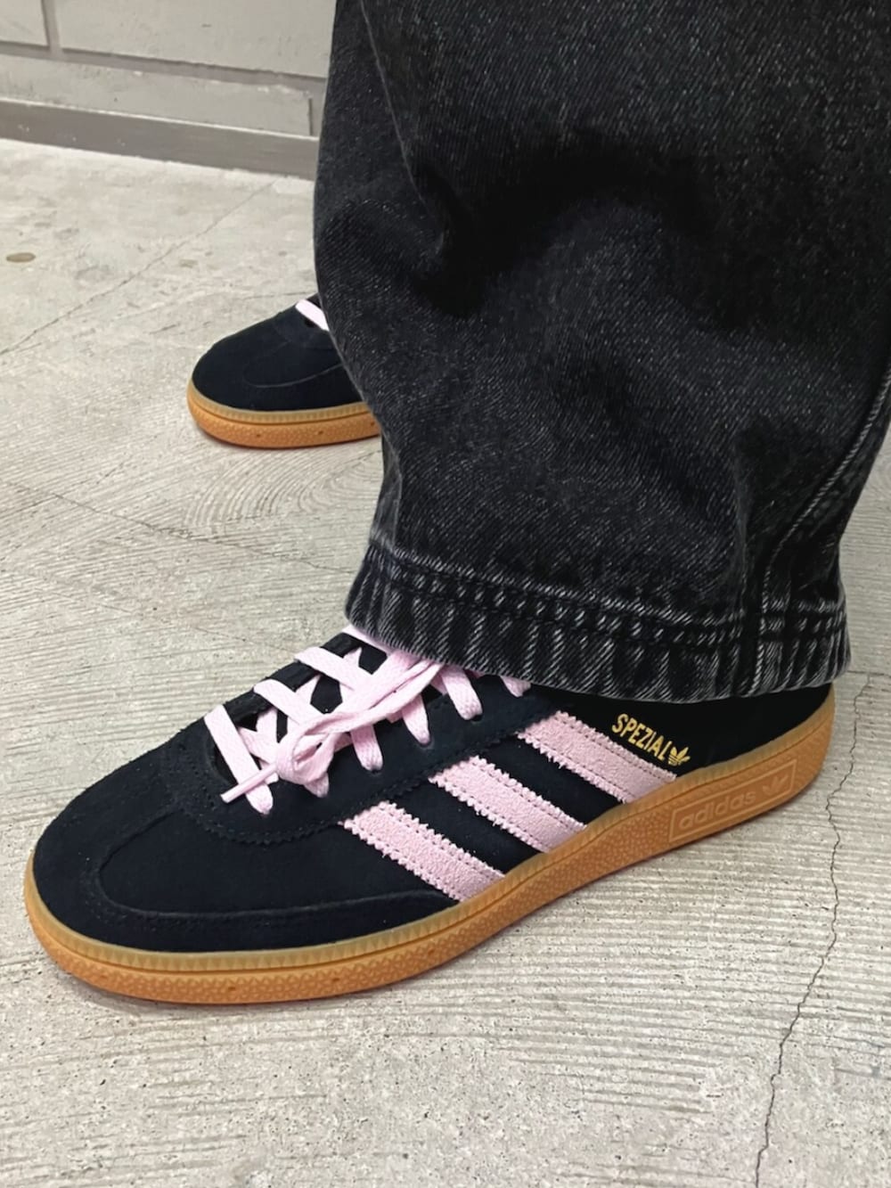 ブラック系のブルゾン、ブラック系のデニムパンツ、ブラック系のスニーカーを着用したレディースの春コーディネートの2枚目の写真