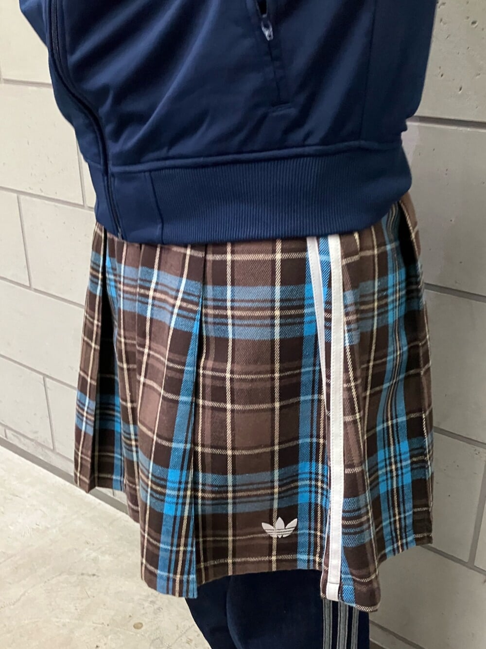 ブラウン系のスカート、ブルー系のジャージ、ブルー系のデニムパンツを着用したレディースの冬コーディネートの3枚目の写真