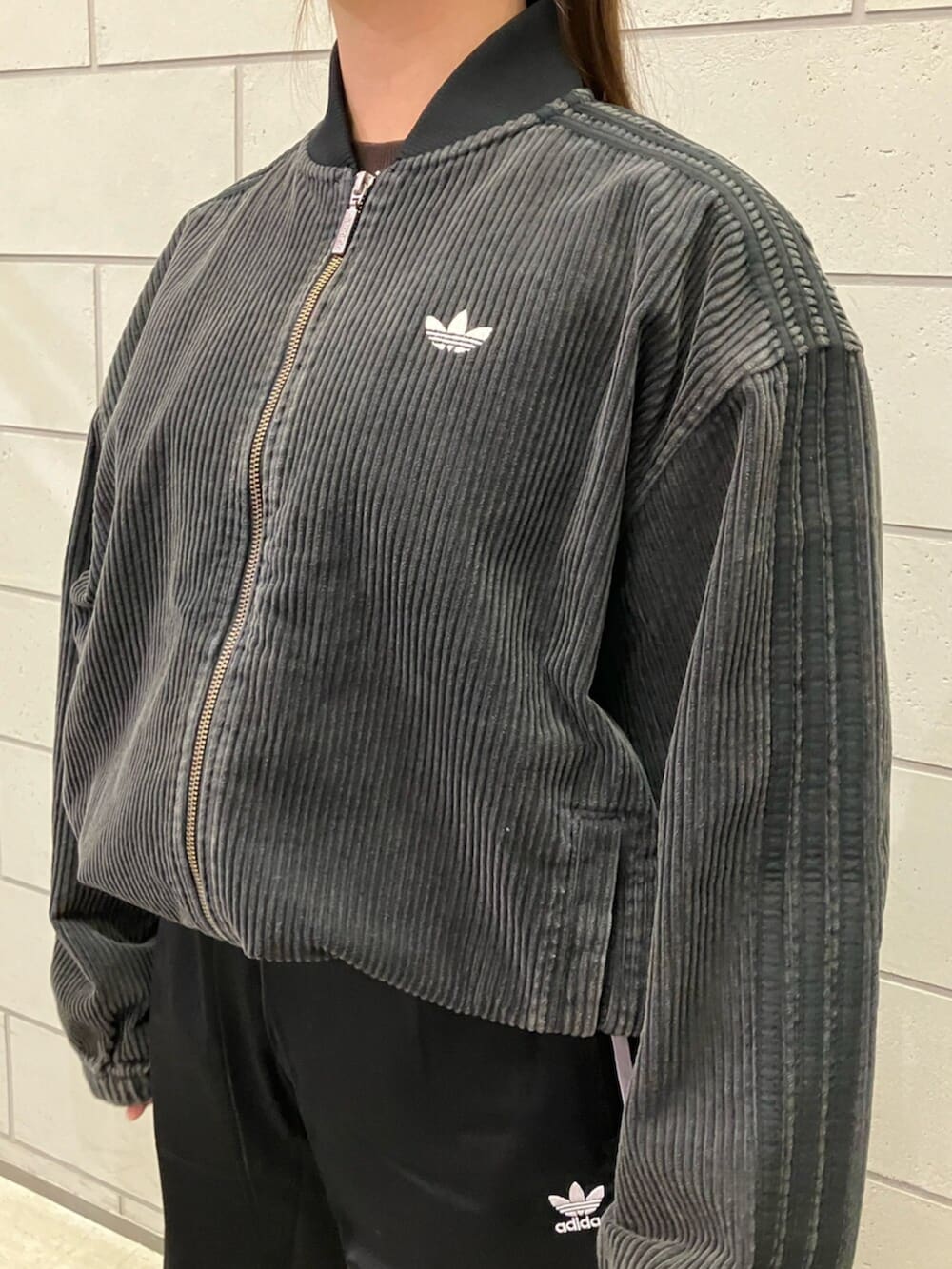 ブラック系のブルゾン、ブラック系のスウェットパンツ、ブラック系のスニーカーを着用したレディースの冬コーディネートの2枚目の写真