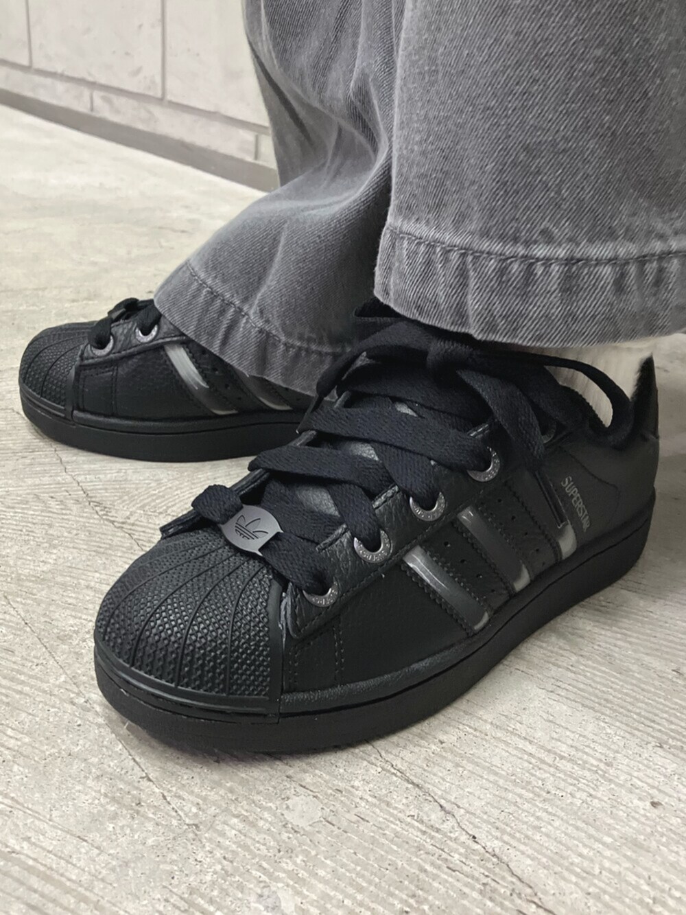 ホワイト系のTシャツ/カットソー、グレー系のデニムパンツ、ブラック系のスニーカーを着用したレディースの夏コーディネートの6枚目の写真