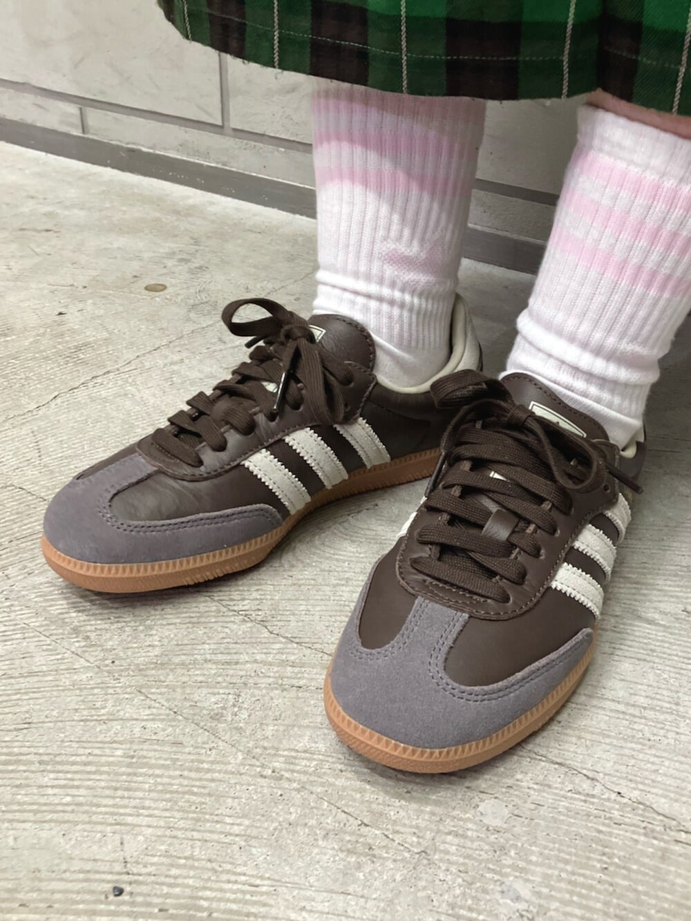 ブルー系のベスト、ブラウン系のスニーカー、ブルー系のポロシャツを着用したレディースの秋コーディネートの4枚目の写真