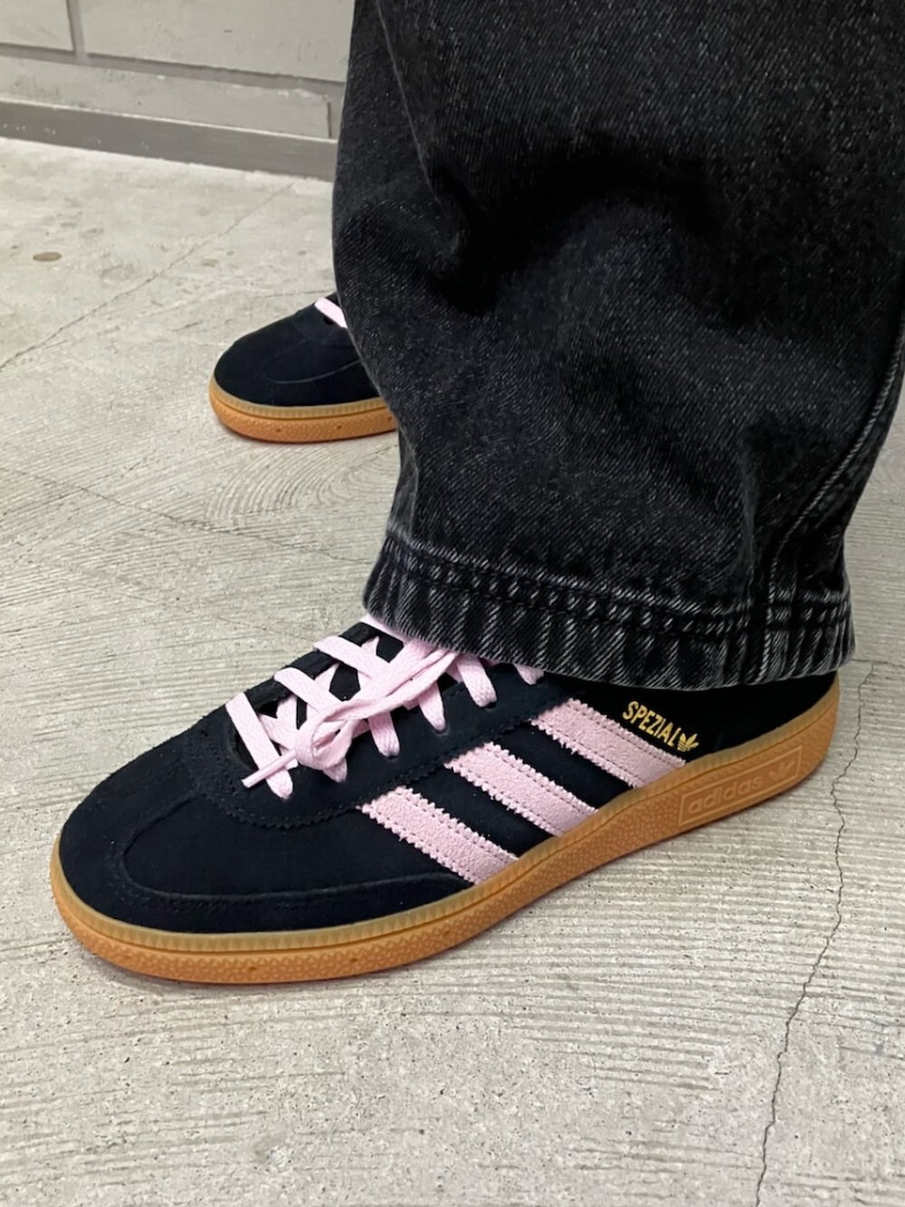 ブラック系のジャージ、ブラック系のデニムパンツ、ブラック系のスニーカーを着用したレディースの春コーディネートの2枚目の写真