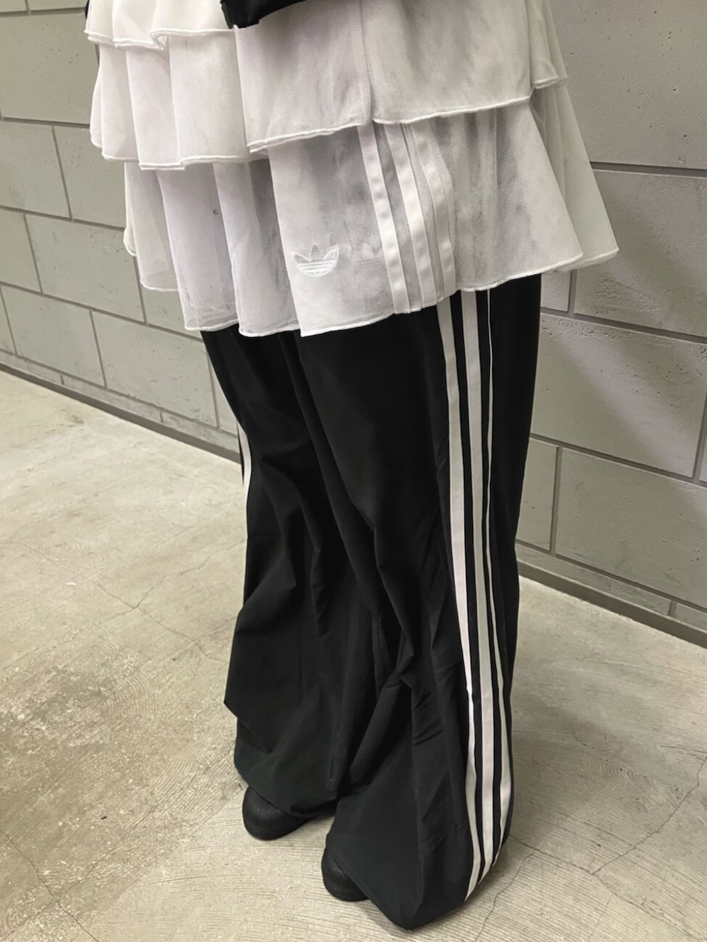 ブラック系のジャージ、ブラック系のスウェットパンツ、ブラック系のシューズを着用したレディースの冬コーディネートの3枚目の写真