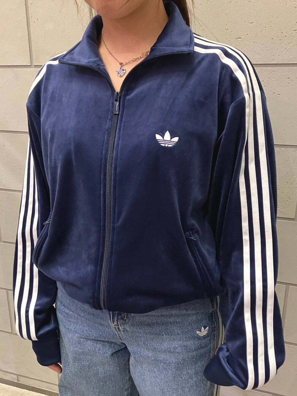 ブルー系のジャージ、ブルー系のデニムパンツ、ベージュ系のスニーカーを着用したレディースの冬コーディネートの2枚目の写真