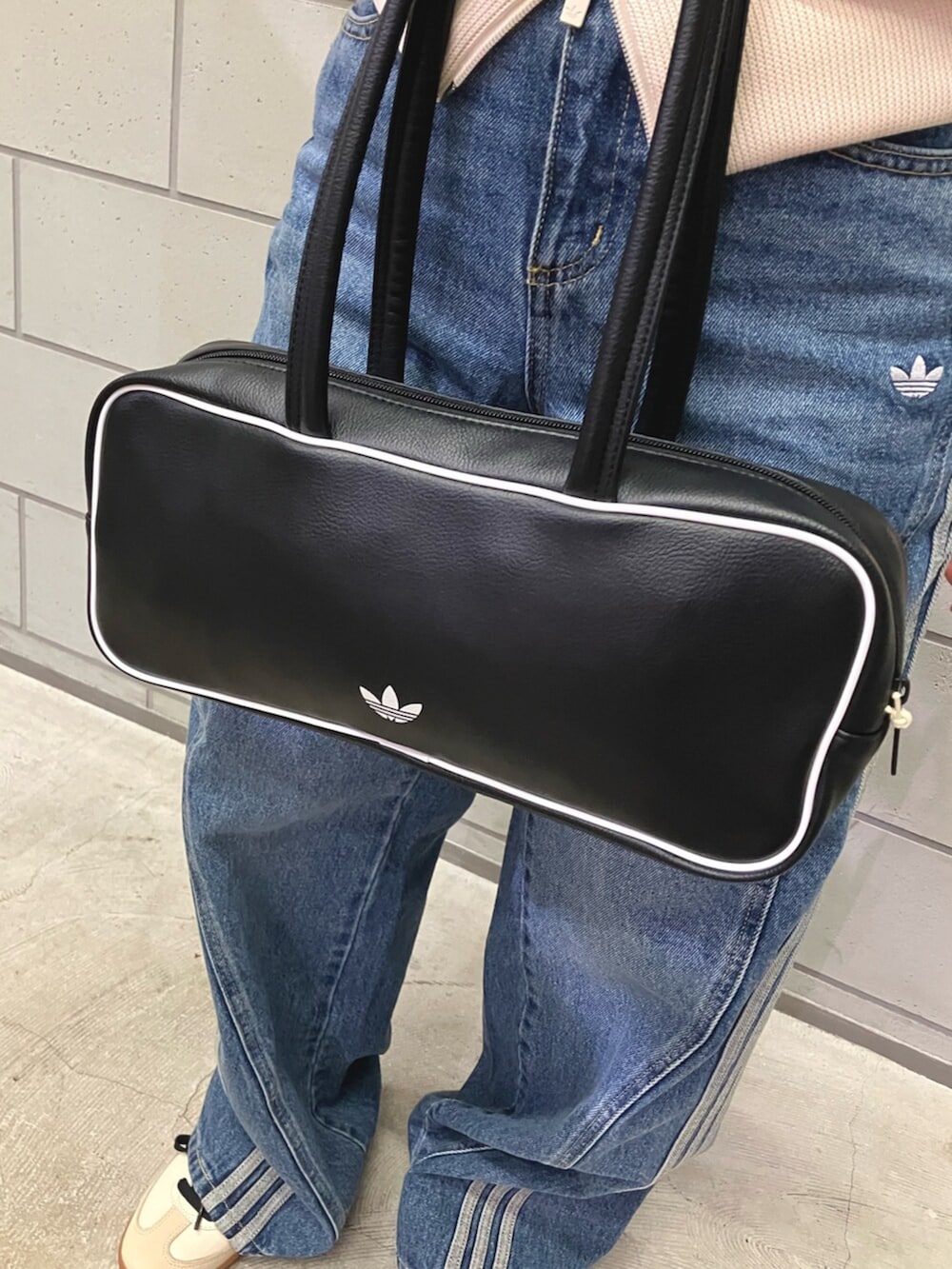 ホワイト系のジャージ、ブルー系のデニムパンツ、ベージュ系のスニーカーを着用したレディースの冬コーディネートの4枚目の写真