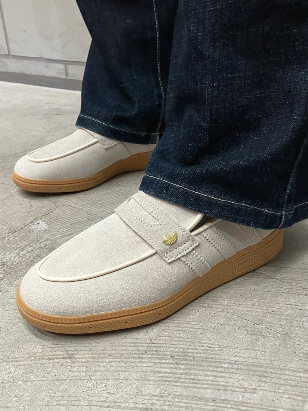 ブラウン系のスカート、ホワイト系のTシャツ/カットソー、ホワイト系のスニーカーを着用したレディースの冬コーディネートの4枚目の写真