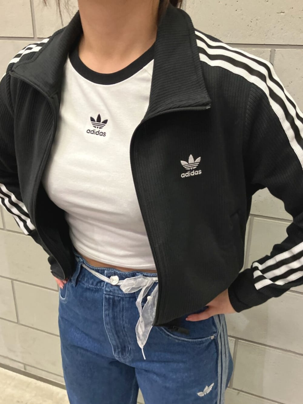 ブルー系のデニムパンツ、ブラック系のジャージ、ホワイト系のTシャツ/カットソーを着用したレディースの冬コーディネートの2枚目の写真