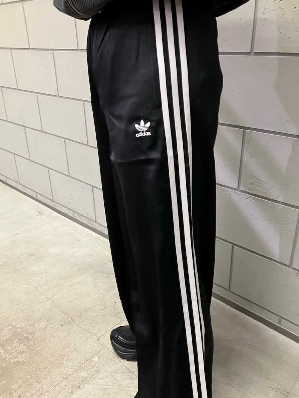 ブラック系のブルゾン、ブラック系のスウェットパンツ、ブラック系のスニーカーを着用したレディースの冬コーディネートの3枚目の写真