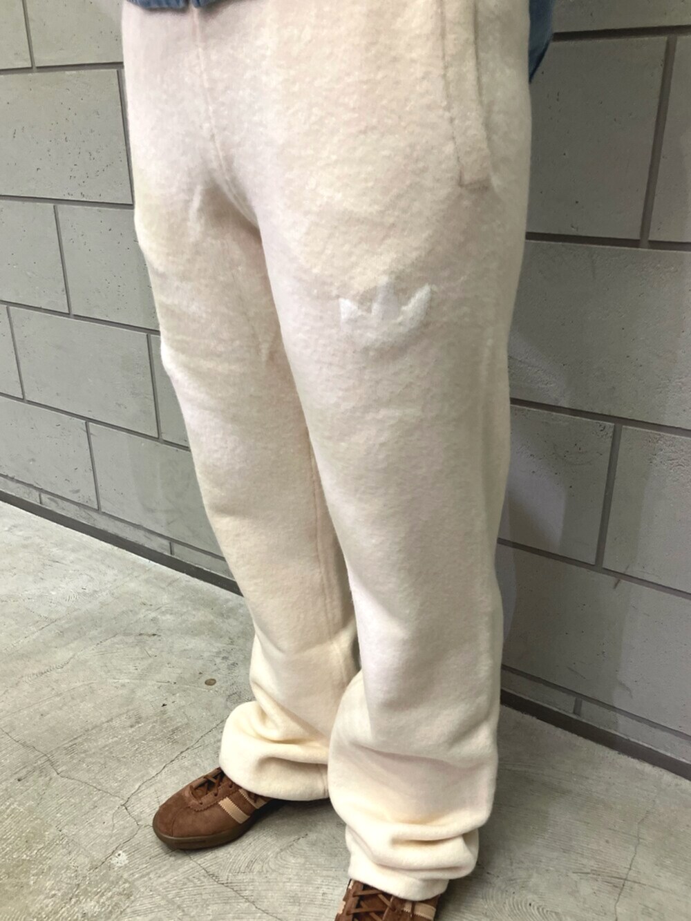 ブルー系のデニムジャケット、ホワイト系のその他パンツ、ブラウン系のスニーカーを着用したレディースの秋コーディネートの3枚目の写真