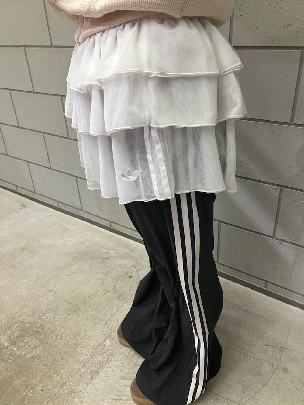 ホワイト系のジャージ、ブラック系のスウェットパンツ、ブラウン系のスニーカーを着用したレディースの冬コーディネートの2枚目の写真