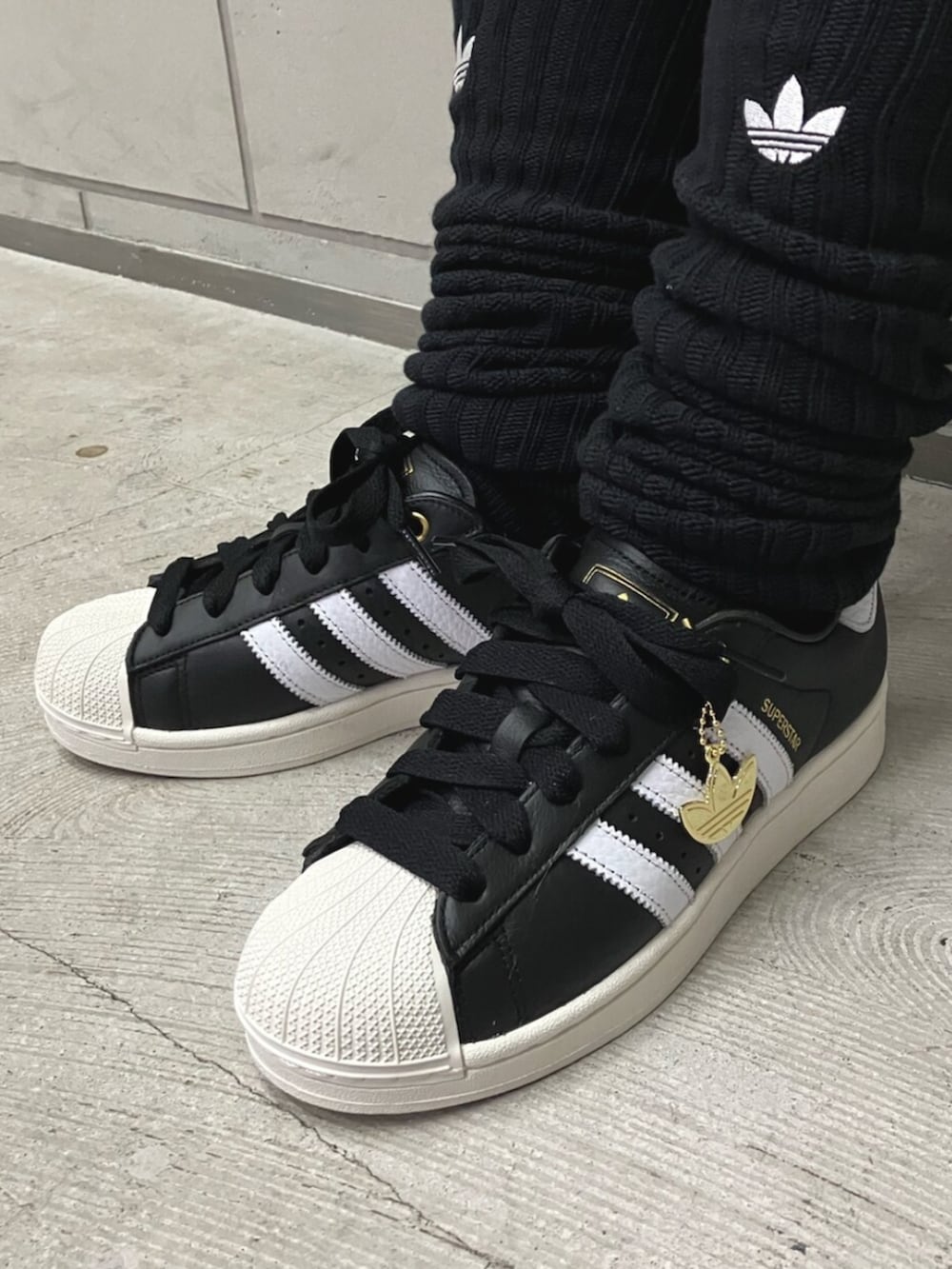 ホワイト系のTシャツ/カットソー、ブラック系のその他パンツ、ブラック系のスニーカーを着用したレディースの春コーディネートの2枚目の写真