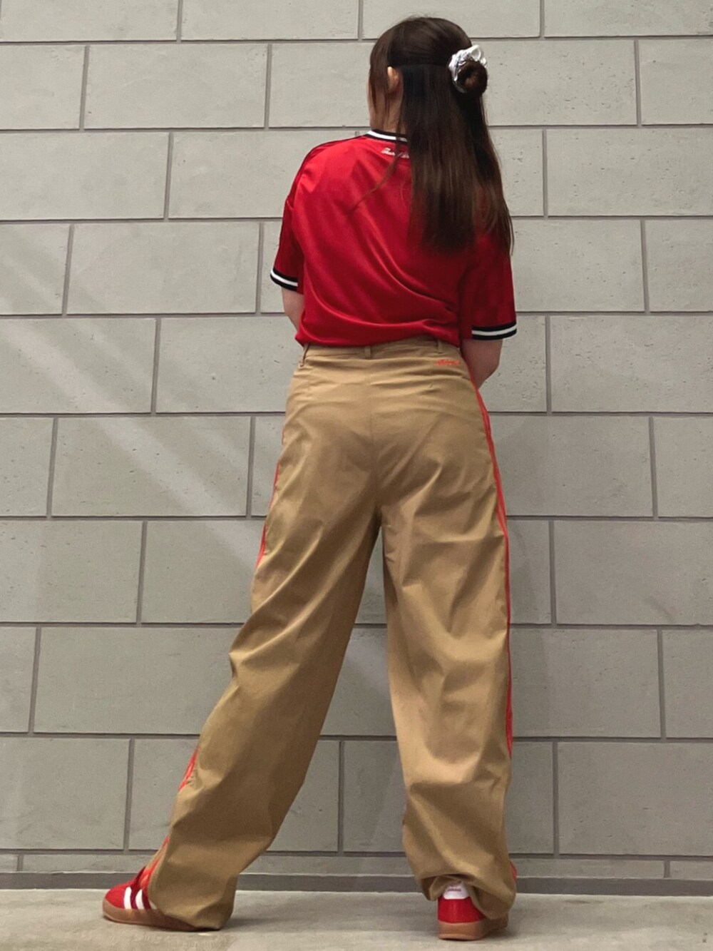 レッド系のスニーカー、ベージュ系のその他パンツ、レッド系のTシャツ/カットソーを着用したレディースの夏コーディネートの3枚目の写真