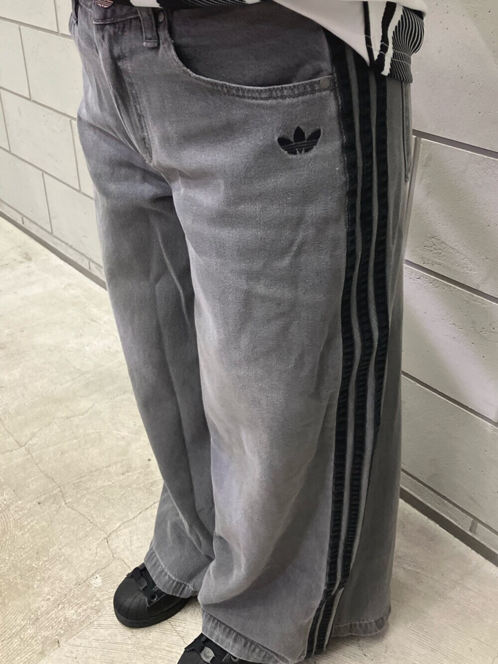 ホワイト系のTシャツ/カットソー、グレー系のデニムパンツ、ブラック系のスニーカーを着用したレディースの夏コーディネートの5枚目の写真