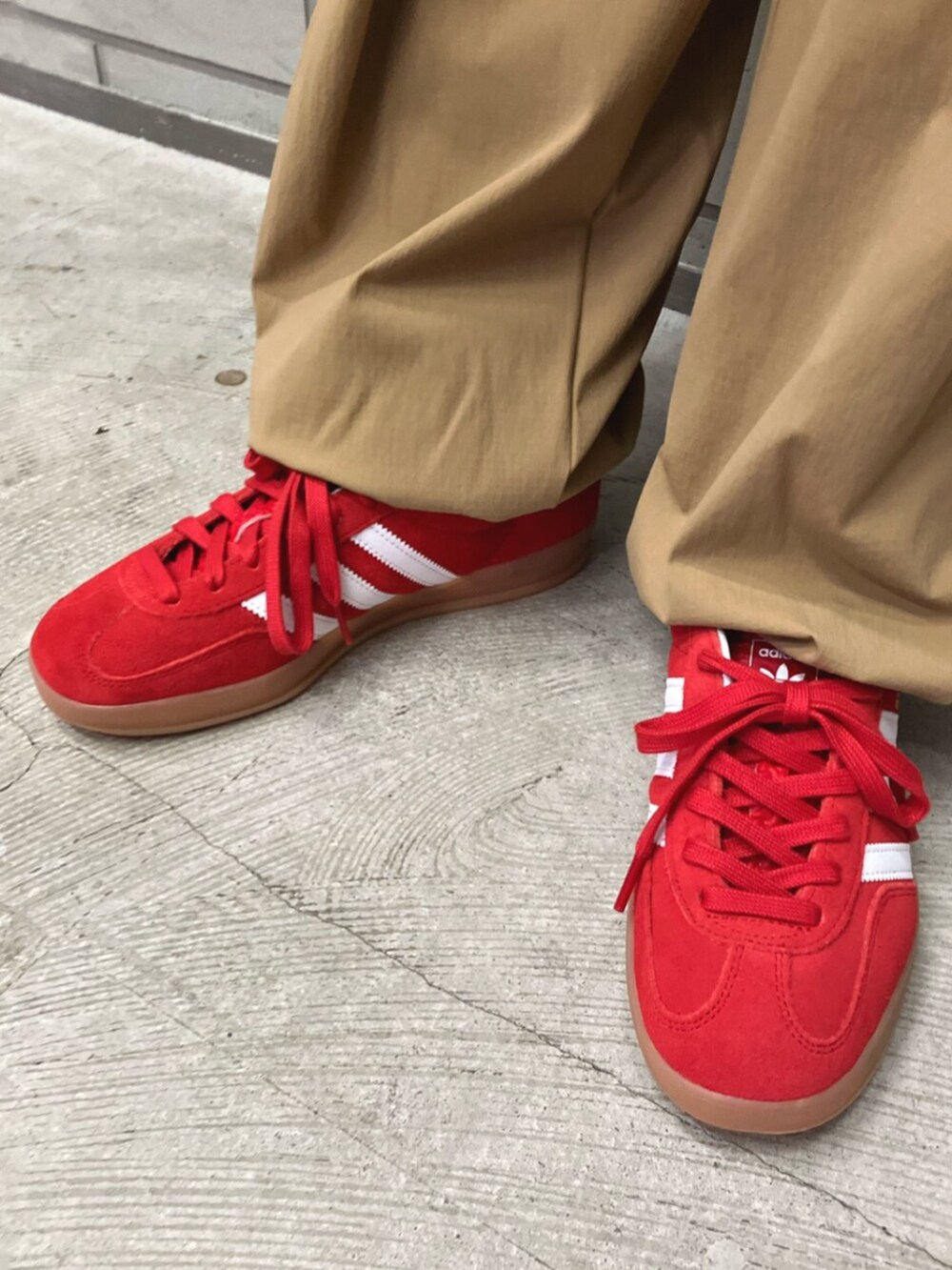 レッド系のスニーカー、ベージュ系のその他パンツ、レッド系のTシャツ/カットソーを着用したレディースの夏コーディネートの6枚目の写真