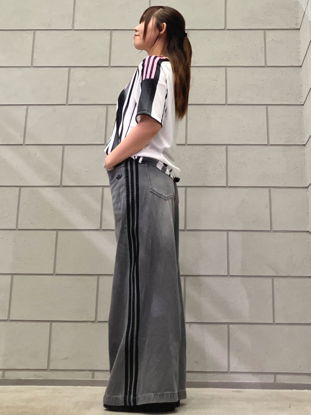 ホワイト系のTシャツ/カットソー、グレー系のデニムパンツ、ブラック系のスニーカーを着用したレディースの夏コーディネートの2枚目の写真