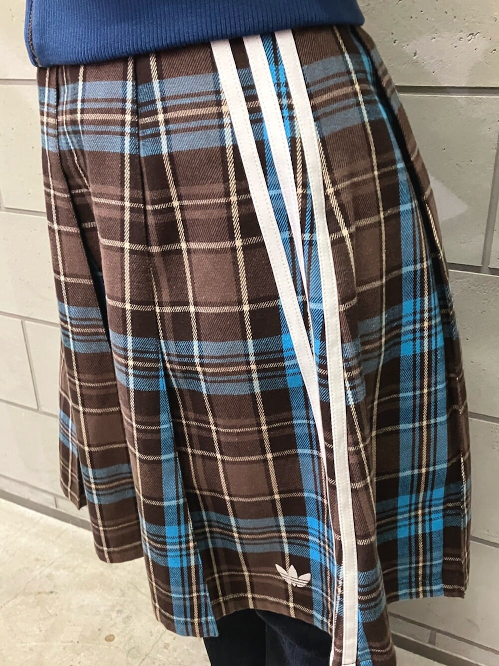 ブルー系のジャージ、ブラウン系のスカート、ホワイト系のスニーカーを着用したレディースの冬コーディネートの3枚目の写真