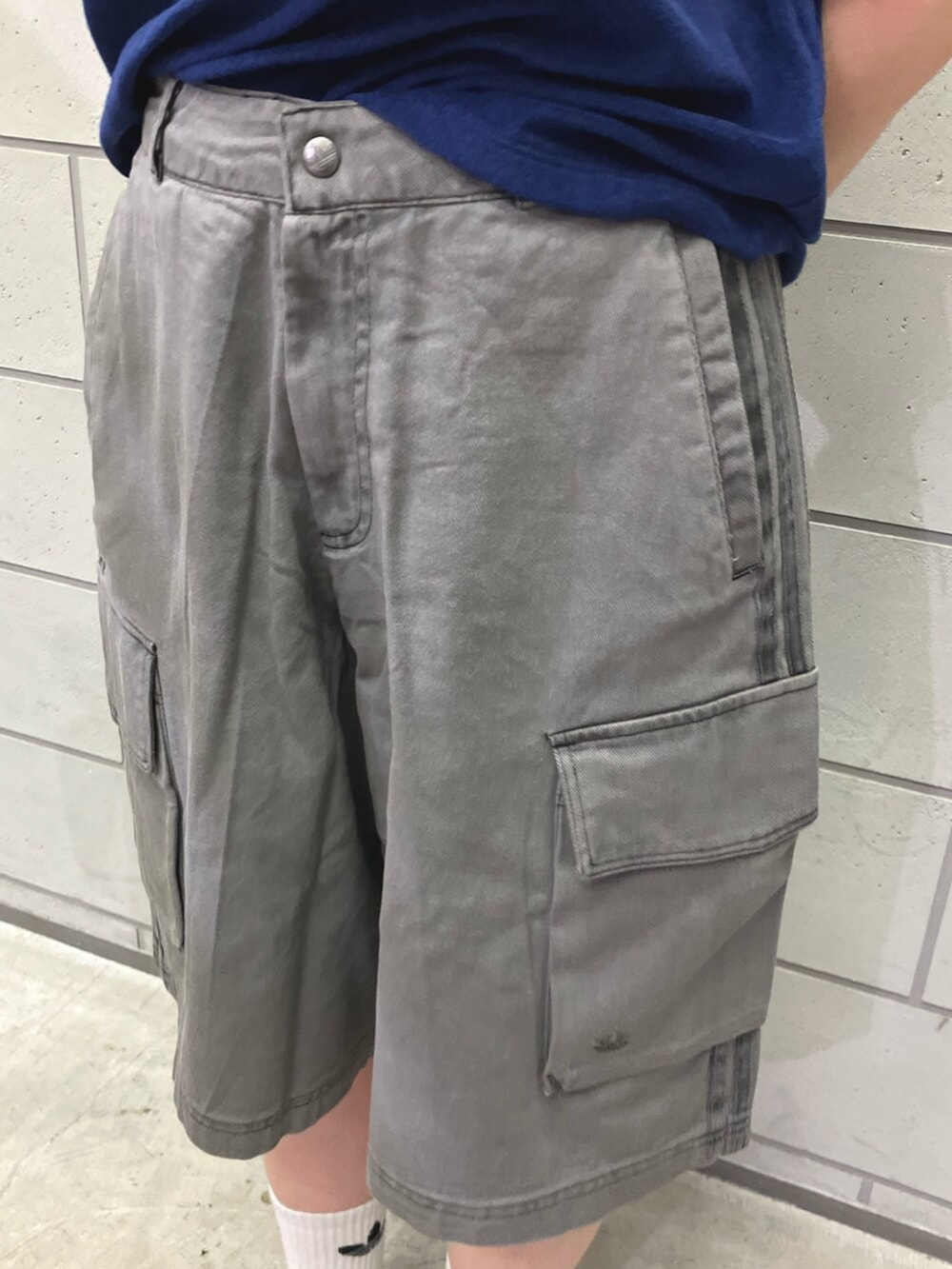 ブルー系のTシャツ/カットソー、ブラック系のカーゴパンツ、ブルー系のスニーカーを着用したレディースの春コーディネートの3枚目の写真