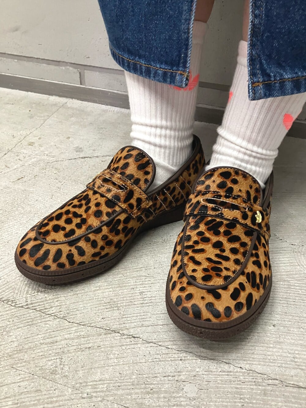 ブラウン系のブルゾン、ブルー系のデニムスカート、ベージュ系のスニーカーを着用したレディースの春コーディネートの2枚目の写真