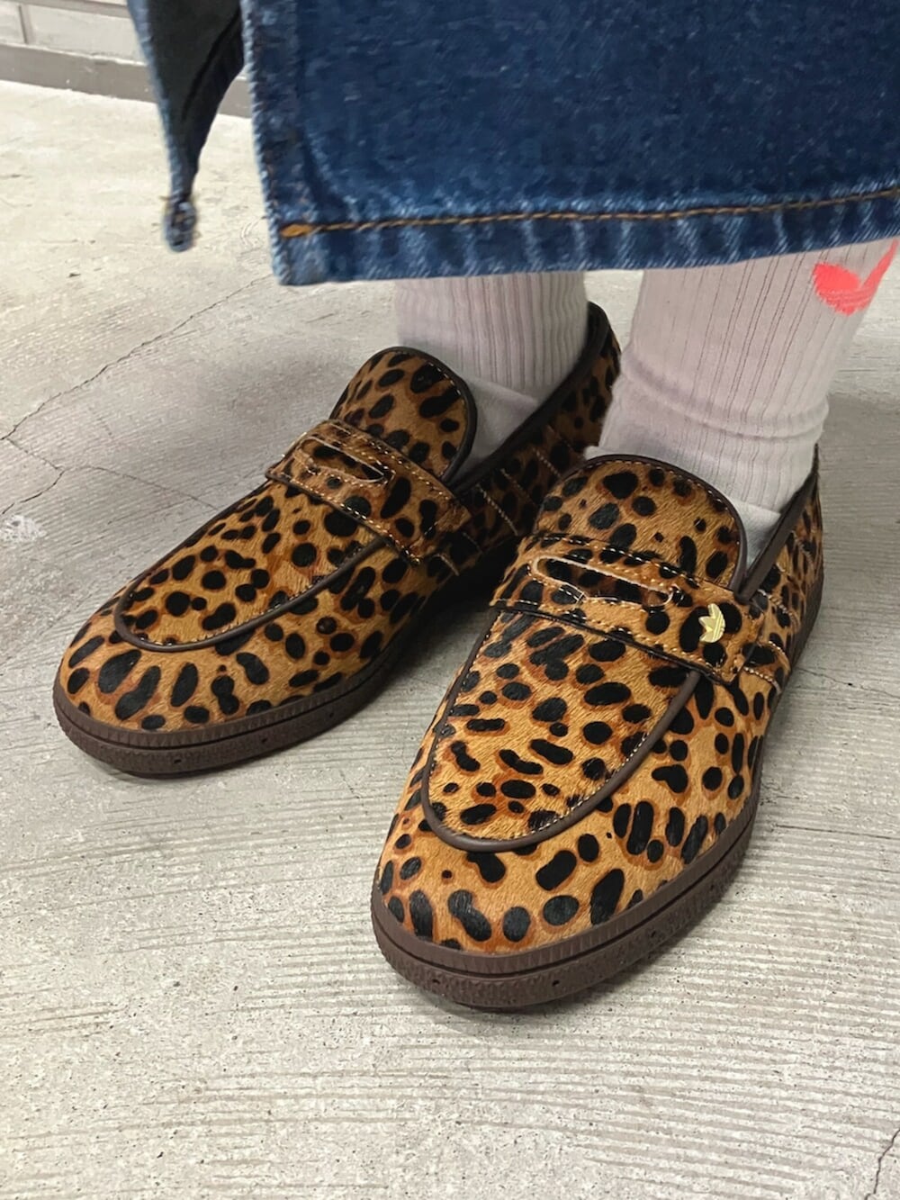 ブルー系のデニムスカート、ブラウン系のブルゾン、ブラウン系のショルダーバッグを着用したレディースの春コーディネートの2枚目の写真