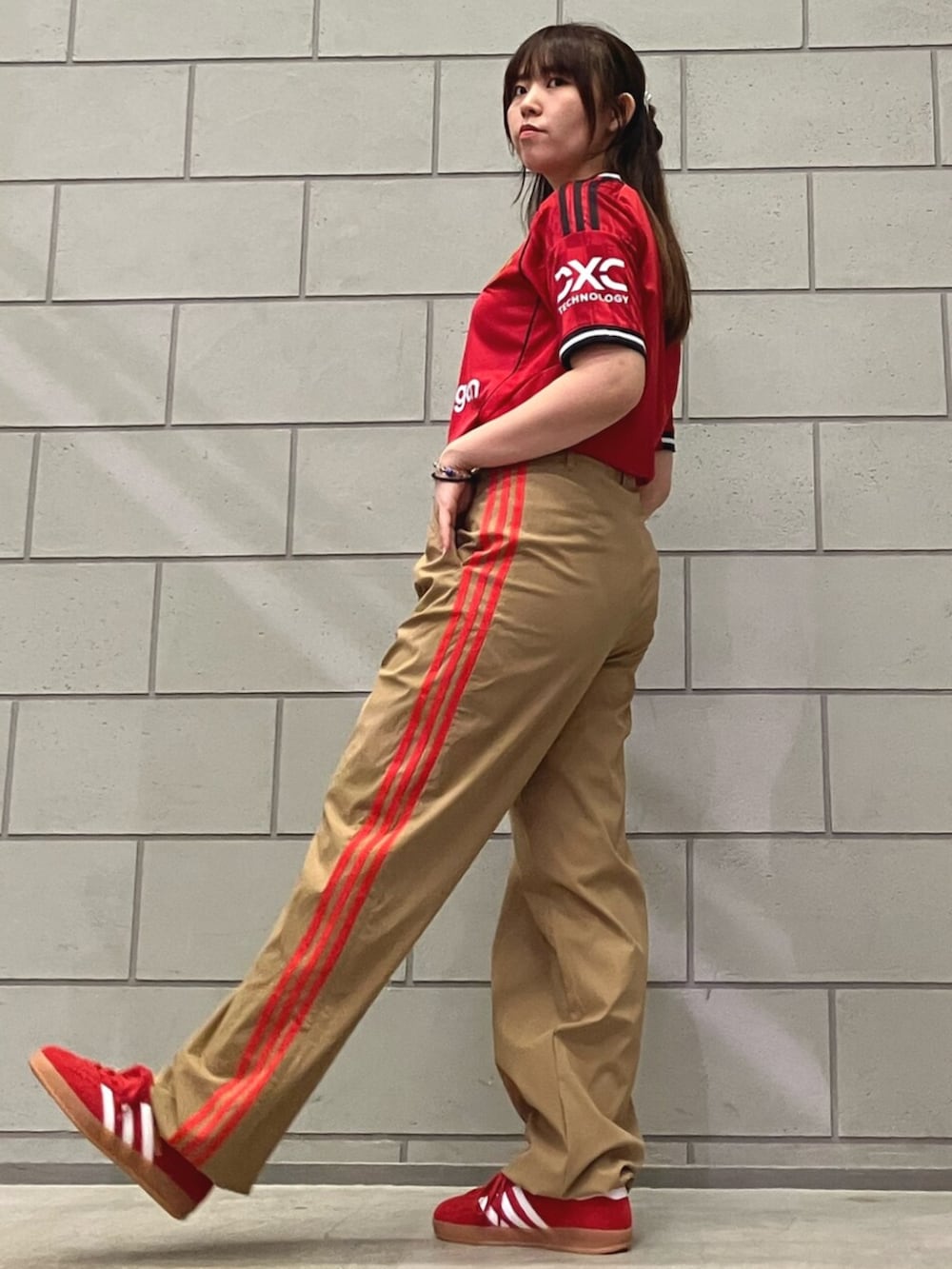 レッド系のスニーカー、ベージュ系のその他パンツ、レッド系のTシャツ/カットソーを着用したレディースの夏コーディネートの2枚目の写真